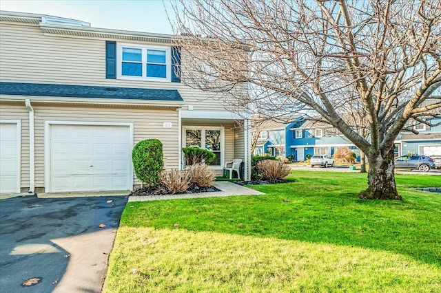 view of property featuring a garage and a front yard