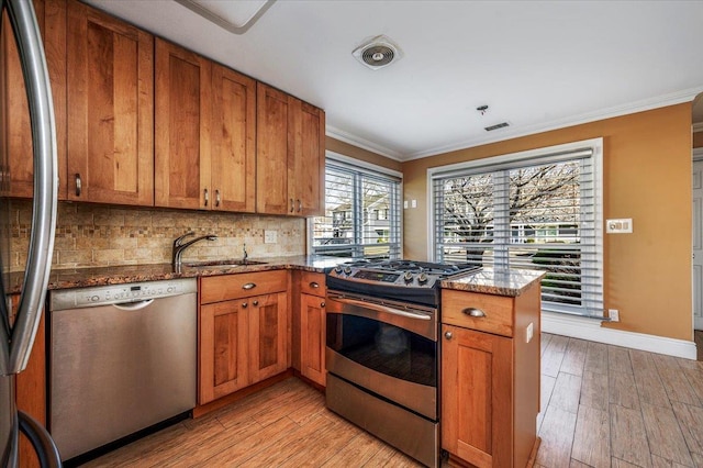 kitchen with sink, light hardwood / wood-style floors, stone countertops, appliances with stainless steel finishes, and ornamental molding