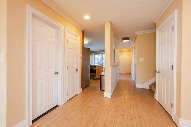 corridor featuring ornamental molding and light hardwood / wood-style flooring