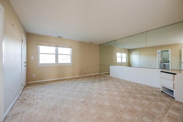 spare room featuring light colored carpet