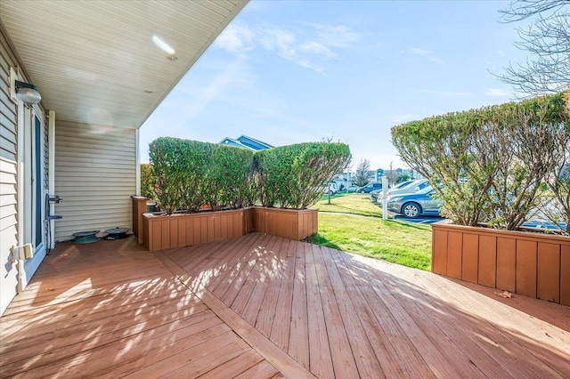 wooden terrace featuring a yard