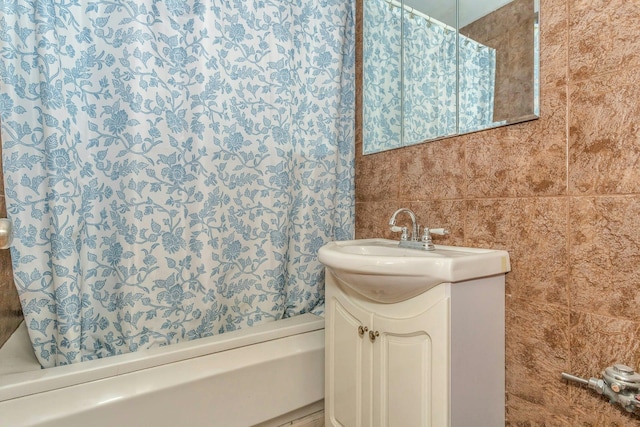 bathroom featuring vanity and tile walls