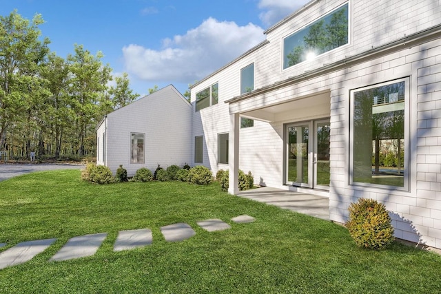 back of house with a lawn and french doors