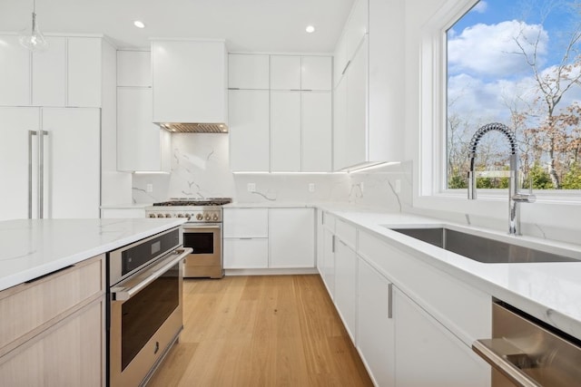 kitchen featuring white cabinets, decorative light fixtures, high quality appliances, and sink