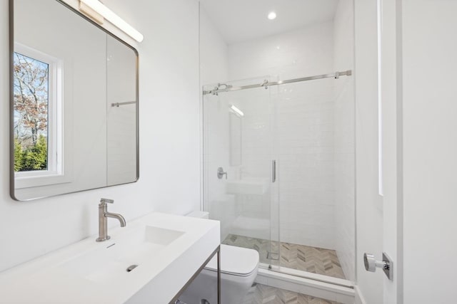 bathroom with sink, an enclosed shower, and toilet