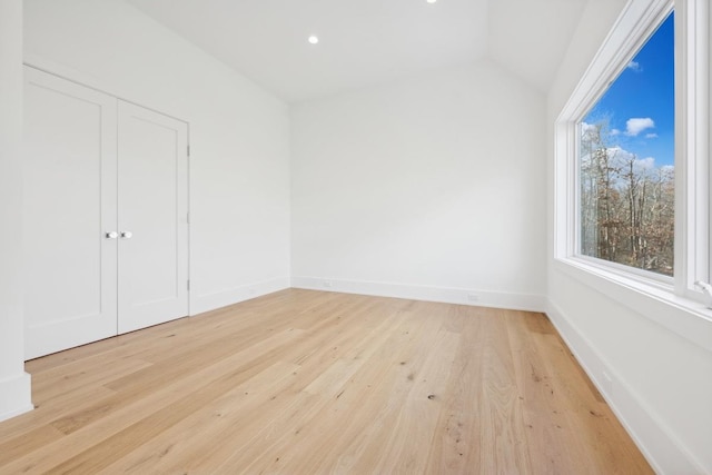 interior space with light hardwood / wood-style floors and vaulted ceiling