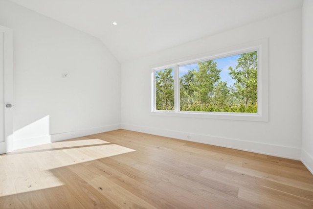 empty room with light wood-type flooring and lofted ceiling