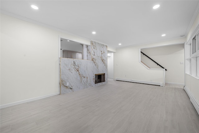 unfurnished living room with light hardwood / wood-style flooring, a baseboard radiator, and ornamental molding