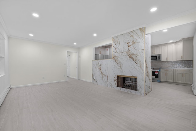 unfurnished living room featuring a high end fireplace, a baseboard radiator, and ornamental molding