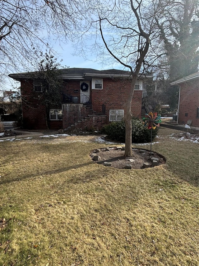 view of front facade with a front lawn and brick siding