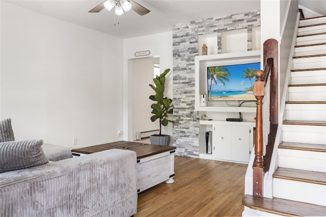 living room with wood-type flooring, a baseboard radiator, and ceiling fan