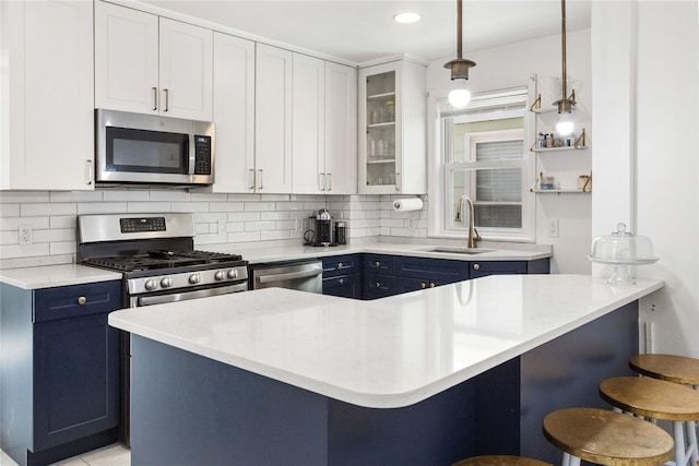 kitchen with blue cabinetry, white cabinetry, a breakfast bar area, and stainless steel appliances