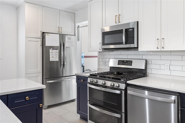 kitchen featuring light stone counters, white cabinetry, stainless steel appliances, and tasteful backsplash