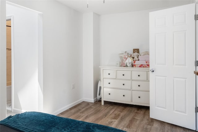 bedroom featuring hardwood / wood-style flooring and ensuite bathroom