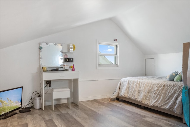 bedroom featuring hardwood / wood-style floors and lofted ceiling