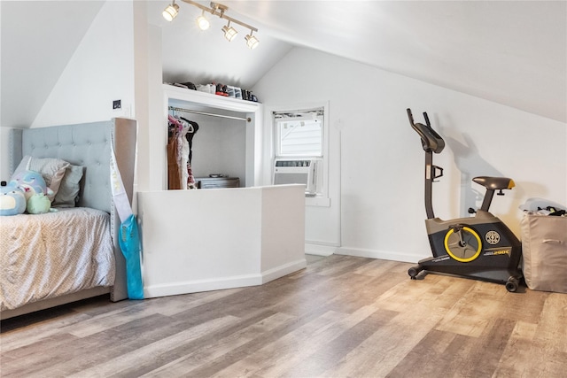 bedroom with cooling unit, hardwood / wood-style flooring, a closet, and lofted ceiling