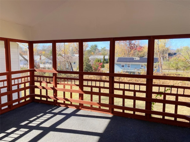 unfurnished sunroom featuring vaulted ceiling