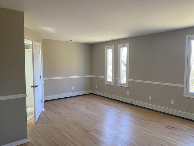 empty room featuring a healthy amount of sunlight and light hardwood / wood-style flooring