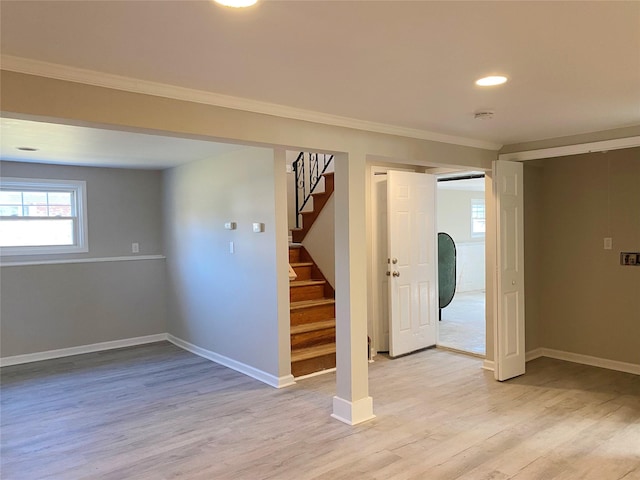 basement with light hardwood / wood-style floors and crown molding