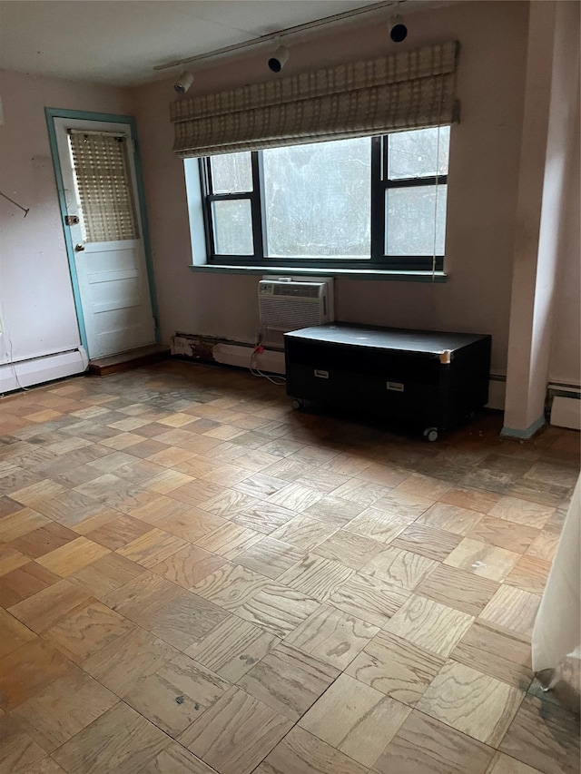 unfurnished room featuring a wall unit AC and a baseboard radiator