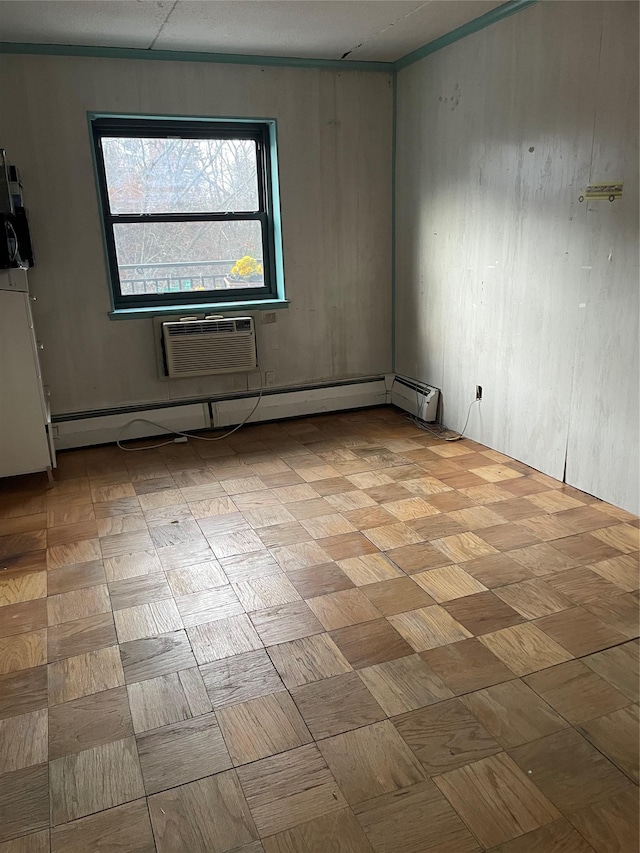 empty room with an AC wall unit, a baseboard radiator, and light parquet floors