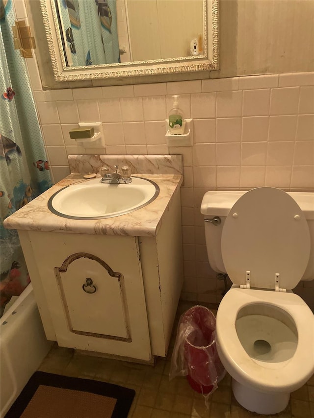 full bathroom featuring tile patterned flooring, vanity, toilet, and tile walls