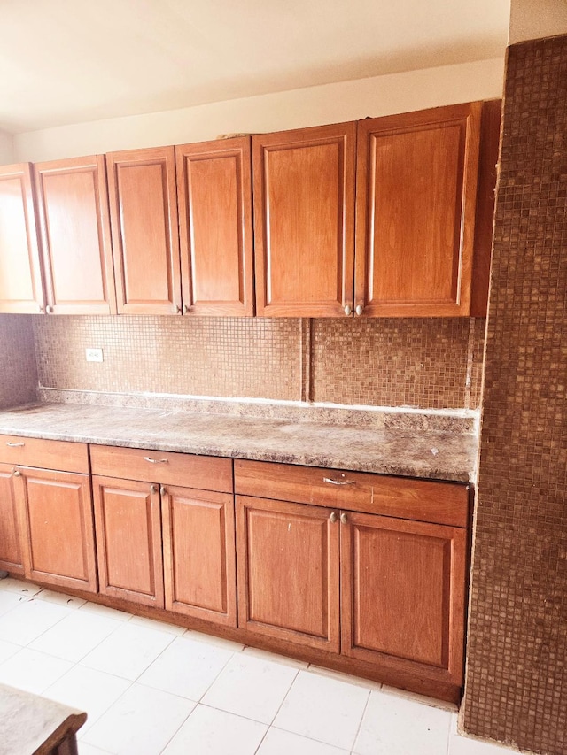 kitchen with tasteful backsplash and light tile patterned flooring