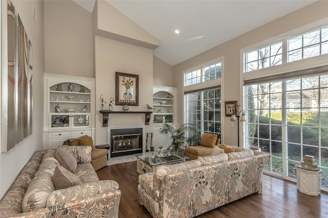 living room featuring built in features, dark hardwood / wood-style floors, and high vaulted ceiling