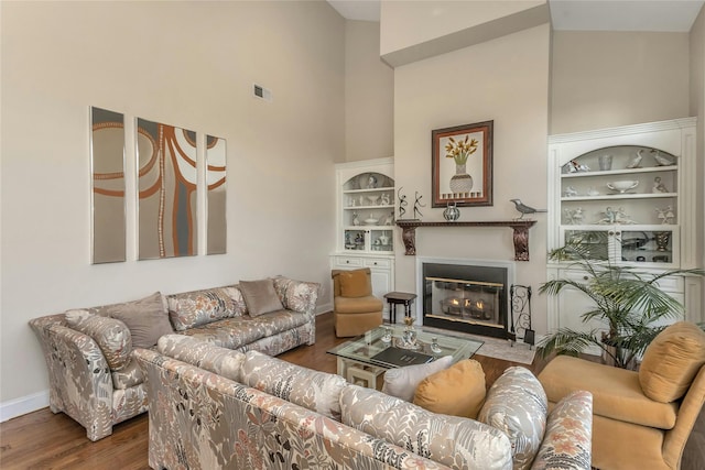 living room with hardwood / wood-style flooring and high vaulted ceiling