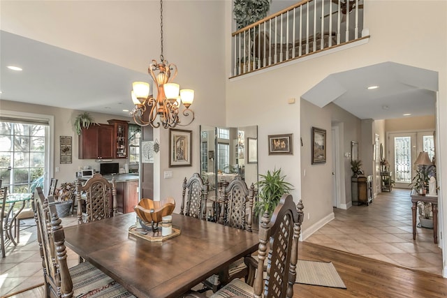 dining room with a chandelier, a high ceiling, light hardwood / wood-style floors, and french doors