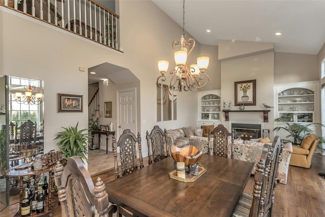 dining room featuring high vaulted ceiling, a chandelier, and hardwood / wood-style flooring