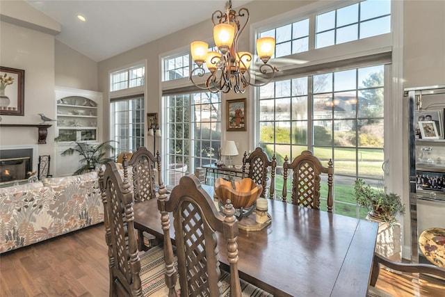 dining room featuring dark hardwood / wood-style flooring, high vaulted ceiling, and an inviting chandelier