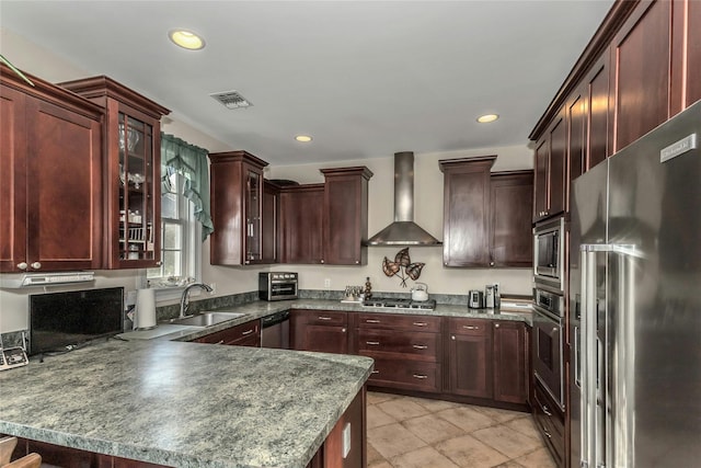 kitchen featuring kitchen peninsula, sink, stainless steel appliances, and wall chimney range hood