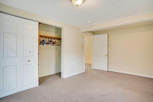 unfurnished bedroom with light carpet and a closet