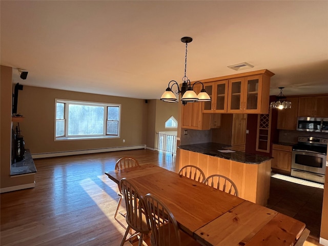 dining space featuring baseboard heating, a chandelier, and dark hardwood / wood-style floors