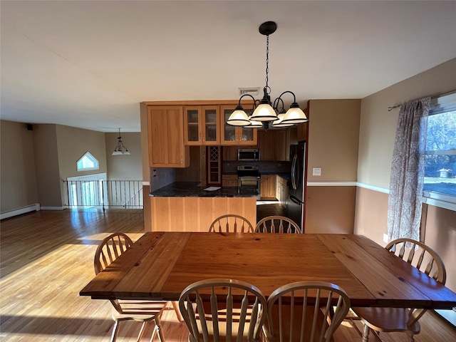 dining space featuring a notable chandelier and light wood-type flooring