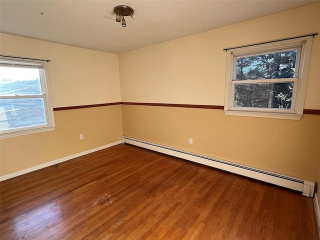 unfurnished room featuring hardwood / wood-style floors and a baseboard radiator