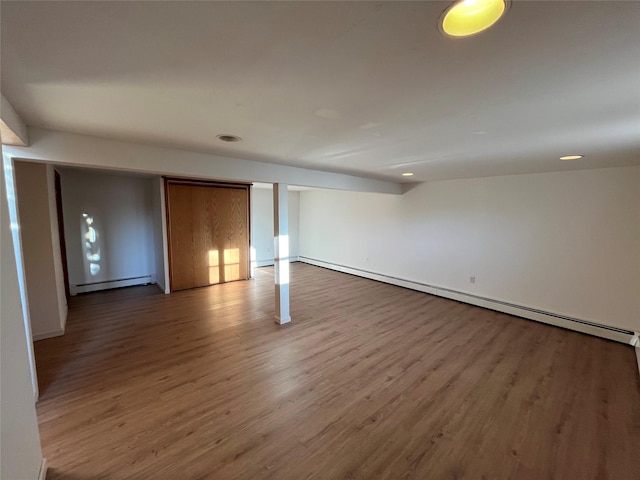 interior space with a baseboard radiator and hardwood / wood-style flooring