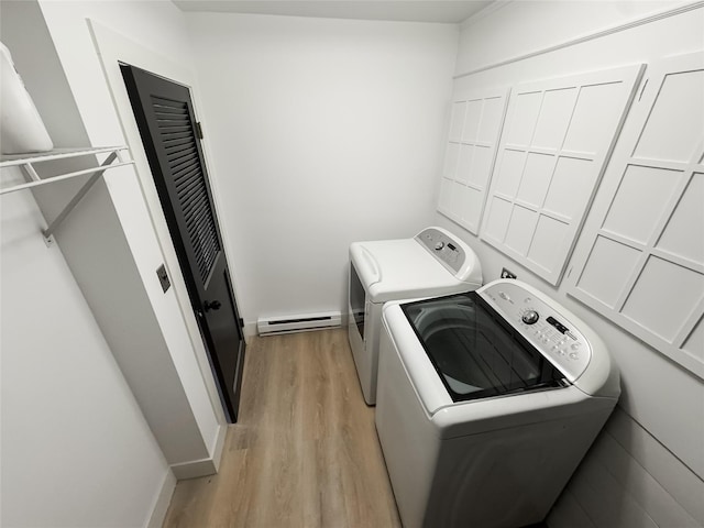 washroom with washing machine and dryer, light hardwood / wood-style floors, and a baseboard radiator