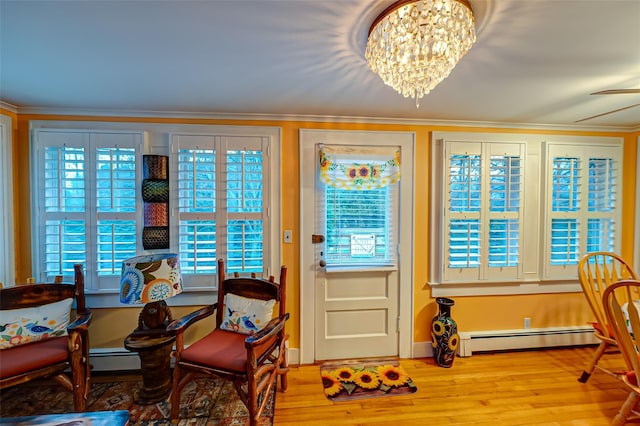 doorway to outside with wood-type flooring, a baseboard radiator, an inviting chandelier, and a wealth of natural light