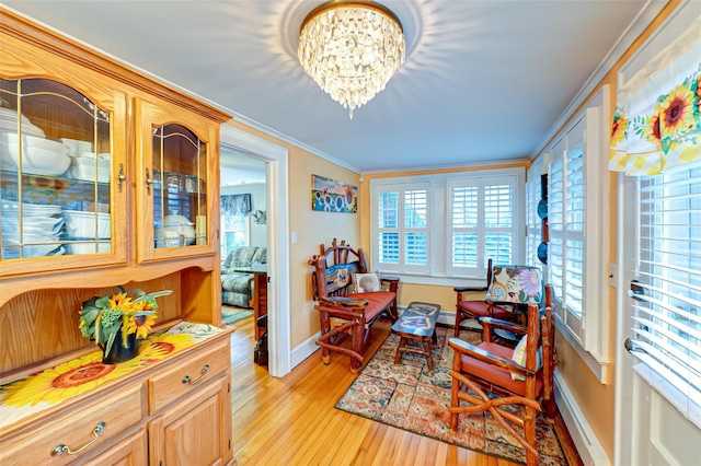 sitting room featuring an inviting chandelier, light hardwood / wood-style flooring, and ornamental molding