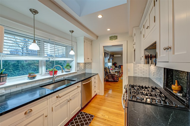 kitchen with stainless steel dishwasher, backsplash, sink, and hanging light fixtures