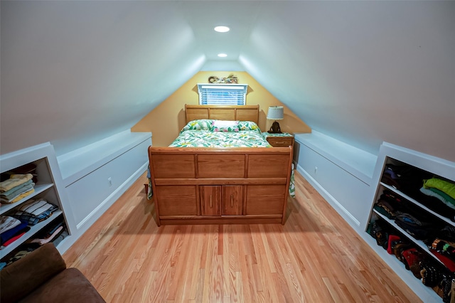 bedroom featuring light wood-type flooring and vaulted ceiling