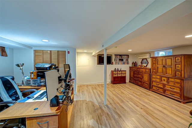 office space featuring a wall mounted air conditioner and light wood-type flooring