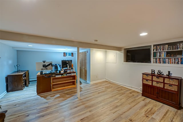 home office with light hardwood / wood-style floors and baseboard heating