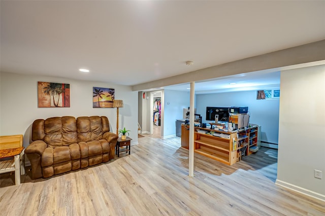 living room with light hardwood / wood-style floors and a baseboard heating unit