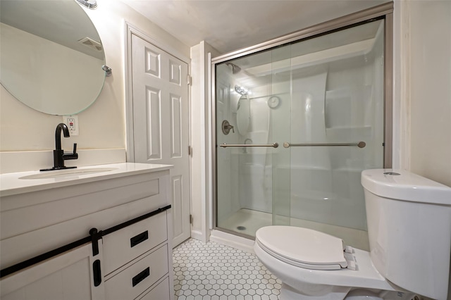 bathroom featuring vanity, a shower with door, tile patterned flooring, and toilet