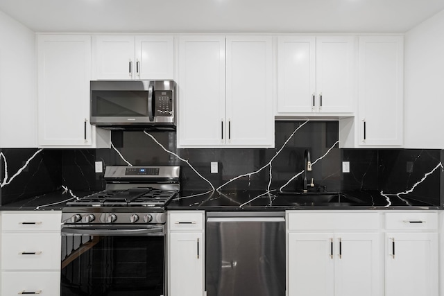 kitchen with white cabinets, appliances with stainless steel finishes, backsplash, and sink