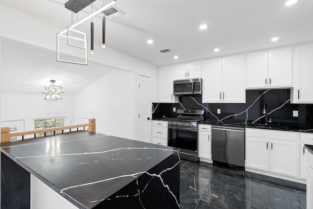 kitchen with white cabinets, sink, tasteful backsplash, decorative light fixtures, and stainless steel appliances