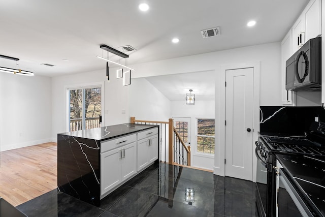 kitchen featuring pendant lighting, dark wood-type flooring, white cabinets, gas stove, and a chandelier